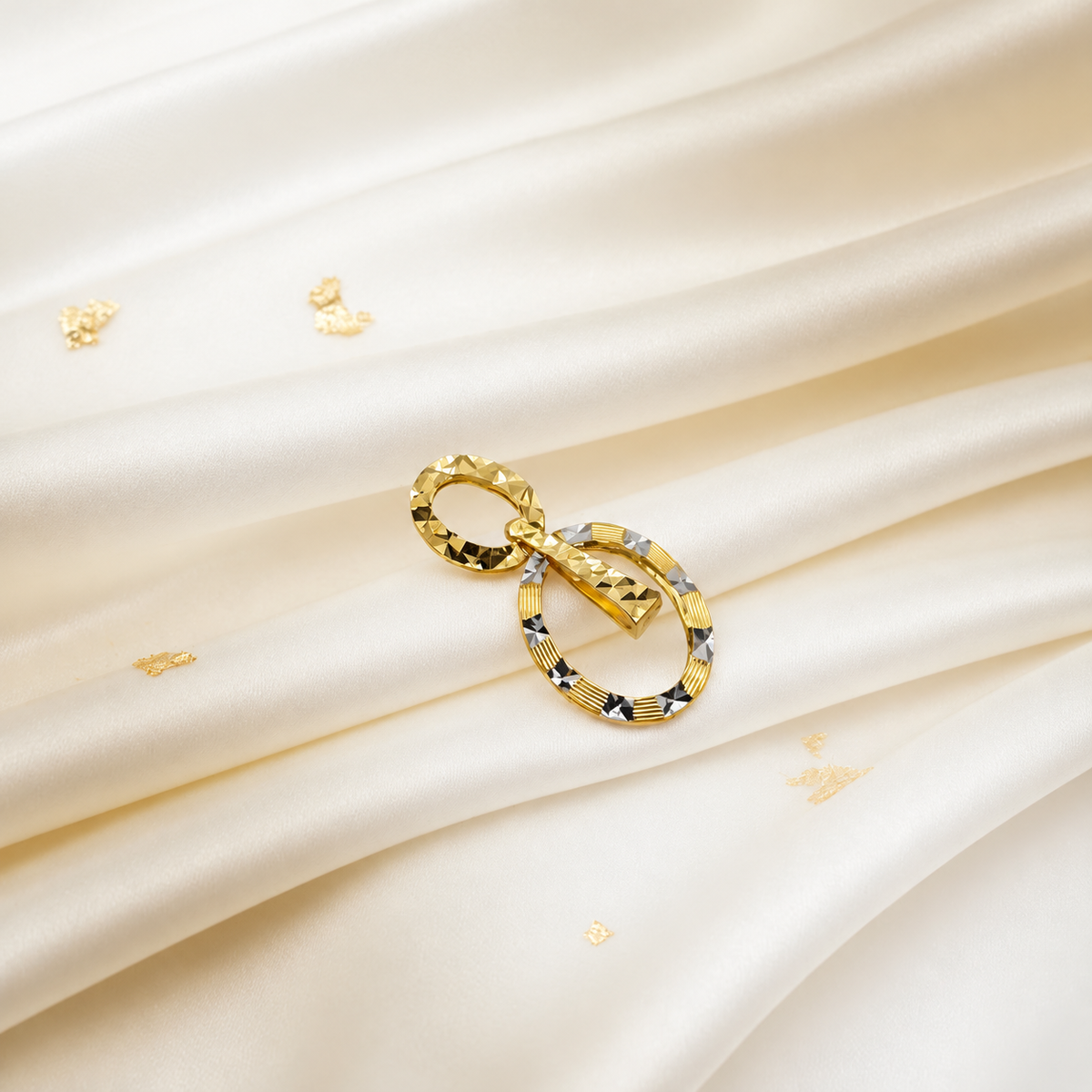 916 gold double-oval pendant angled on ivory satin with contrasting faceted highlights