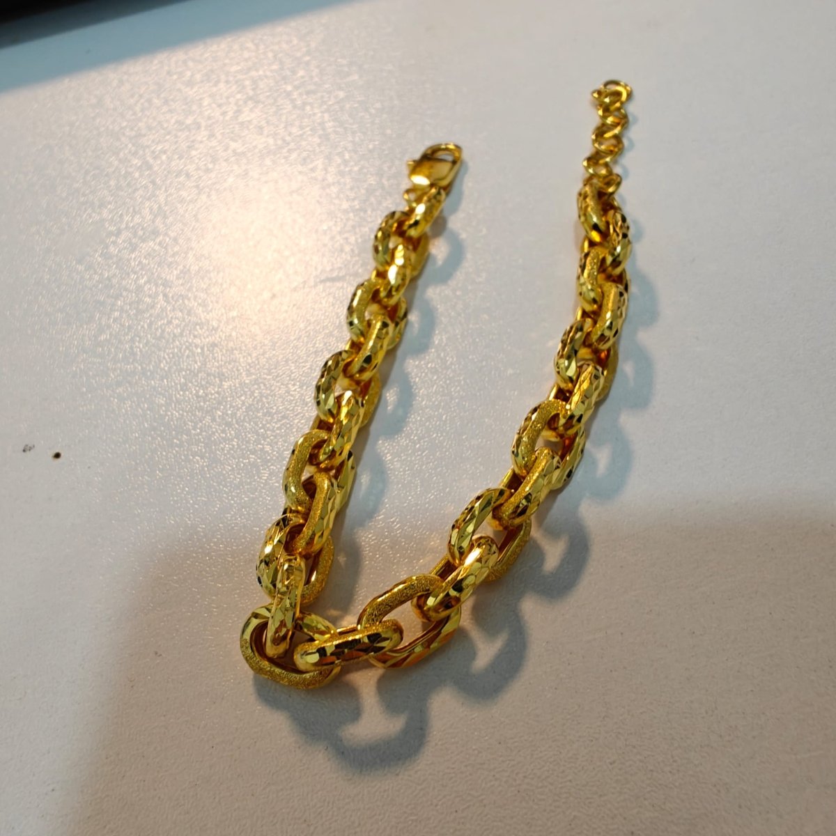 Guild Bullion 22K / 916 gold Golden Anchor Link Bracelet arranged in a U shape showing faceted and textured links and lobster clasp