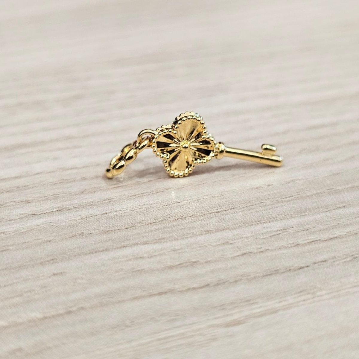 Guild Bullion 916 gold flower key charm; collection design reference. Check selector for current options and availability.