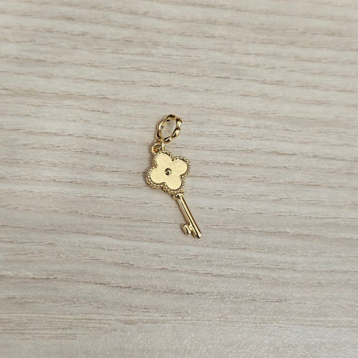 Guild Bullion 916 gold key charm reverse; collection design reference. Check selector for current options and availability.