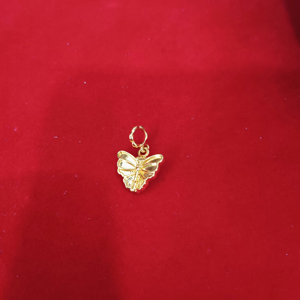 Guild Bullion 916 gold butterfly charm on red background; collection design reference. Check selector for current options and availability.
