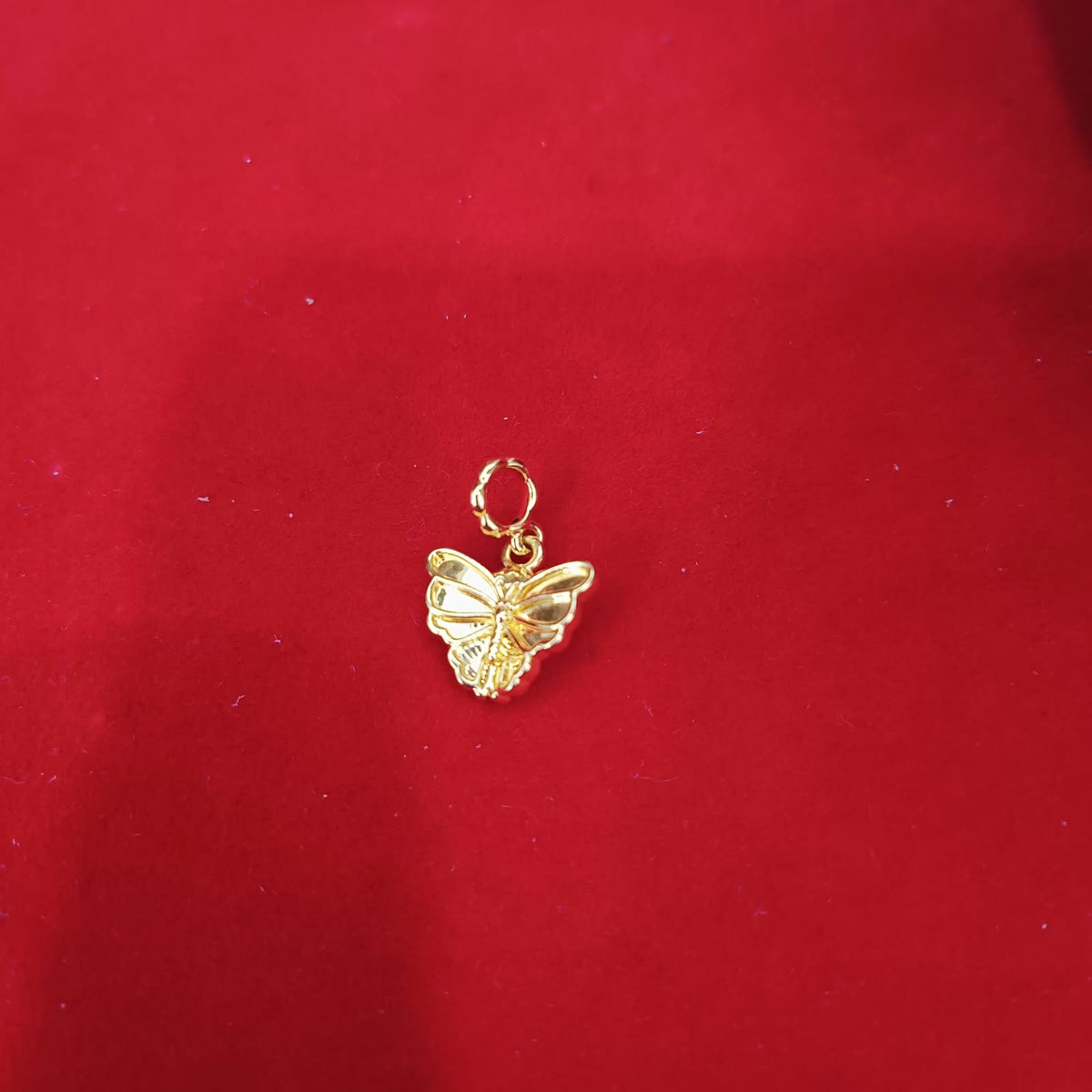 Guild Bullion 916 gold butterfly charm on red background; collection design reference. Check selector for current options and availability.