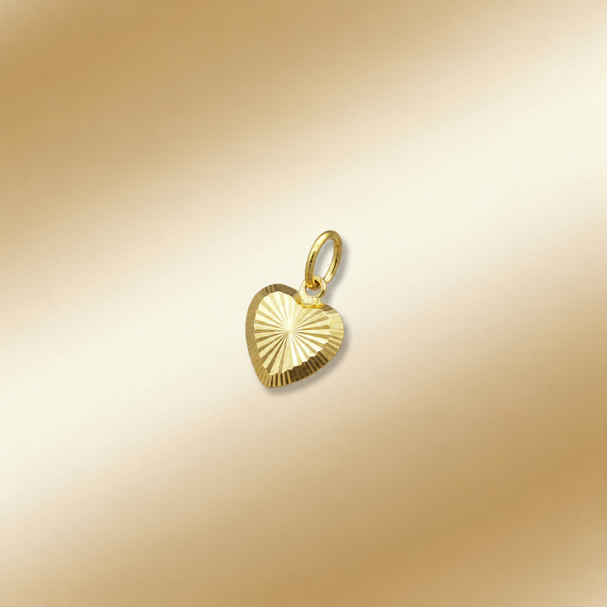 Reference angled view of a radiating-cut 916 gold heart pendant on a cream background