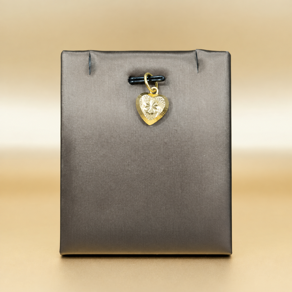 Reference view of a patterned star-centre 916 gold heart pendant on a grey display