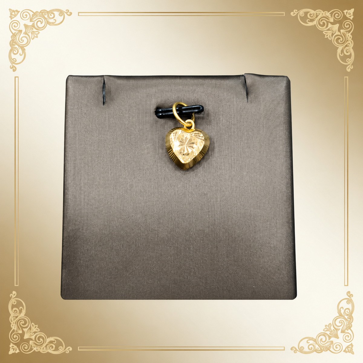Reference view of a patterned star-centre gold heart pendant on a grey display with a decorative border