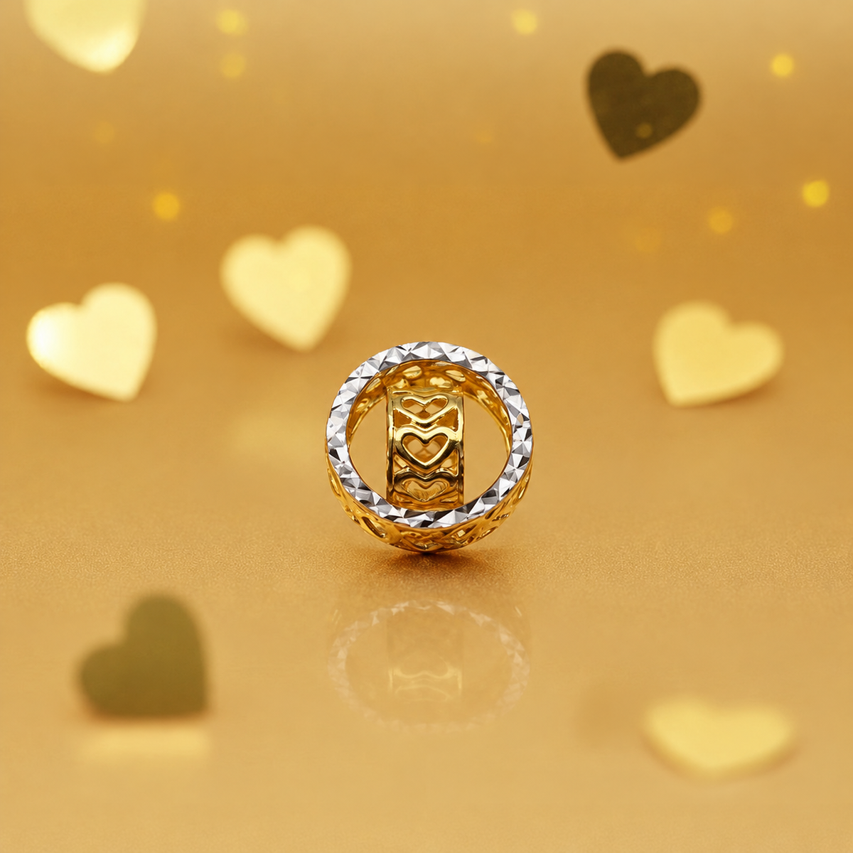 Front view of a two-tone 916 gold heart-motif ring pendant on a gold heart-patterned background