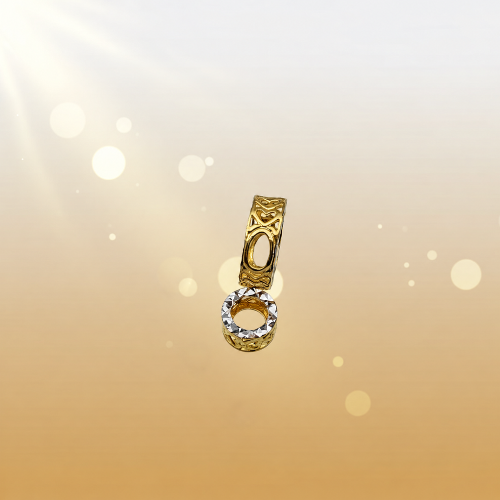 Side detail of gold heart-motif ring forms with a two-tone faceted rim on a cream background