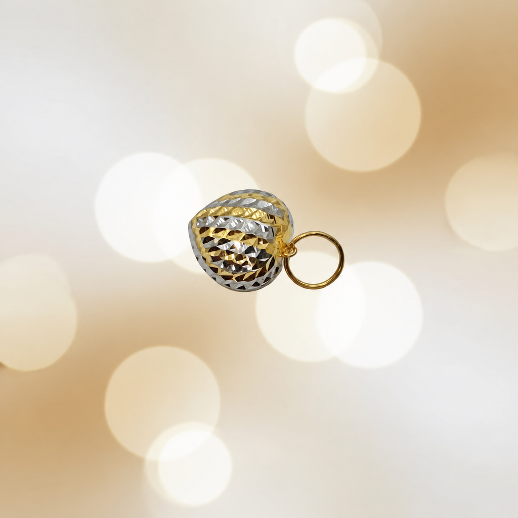 Two-tone 916 faceted heart pendant and gold loop against a cream bokeh background