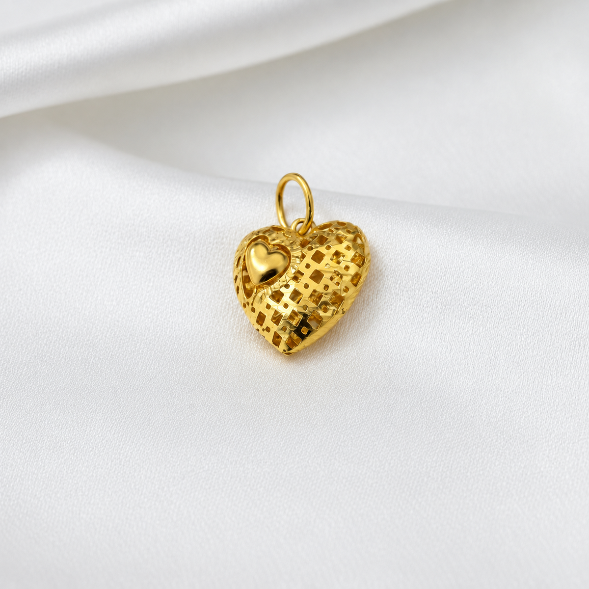 Angled front view of the 916 gold grid-textured heart pendant and raised polished mini heart
