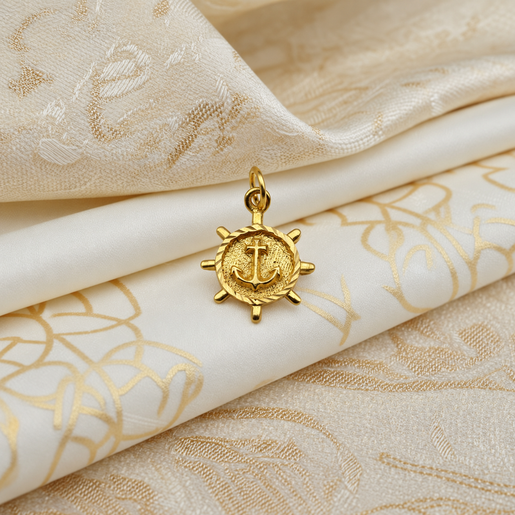 916 gold nautical pendant with raised anchor on a textured ship’s-wheel medallion