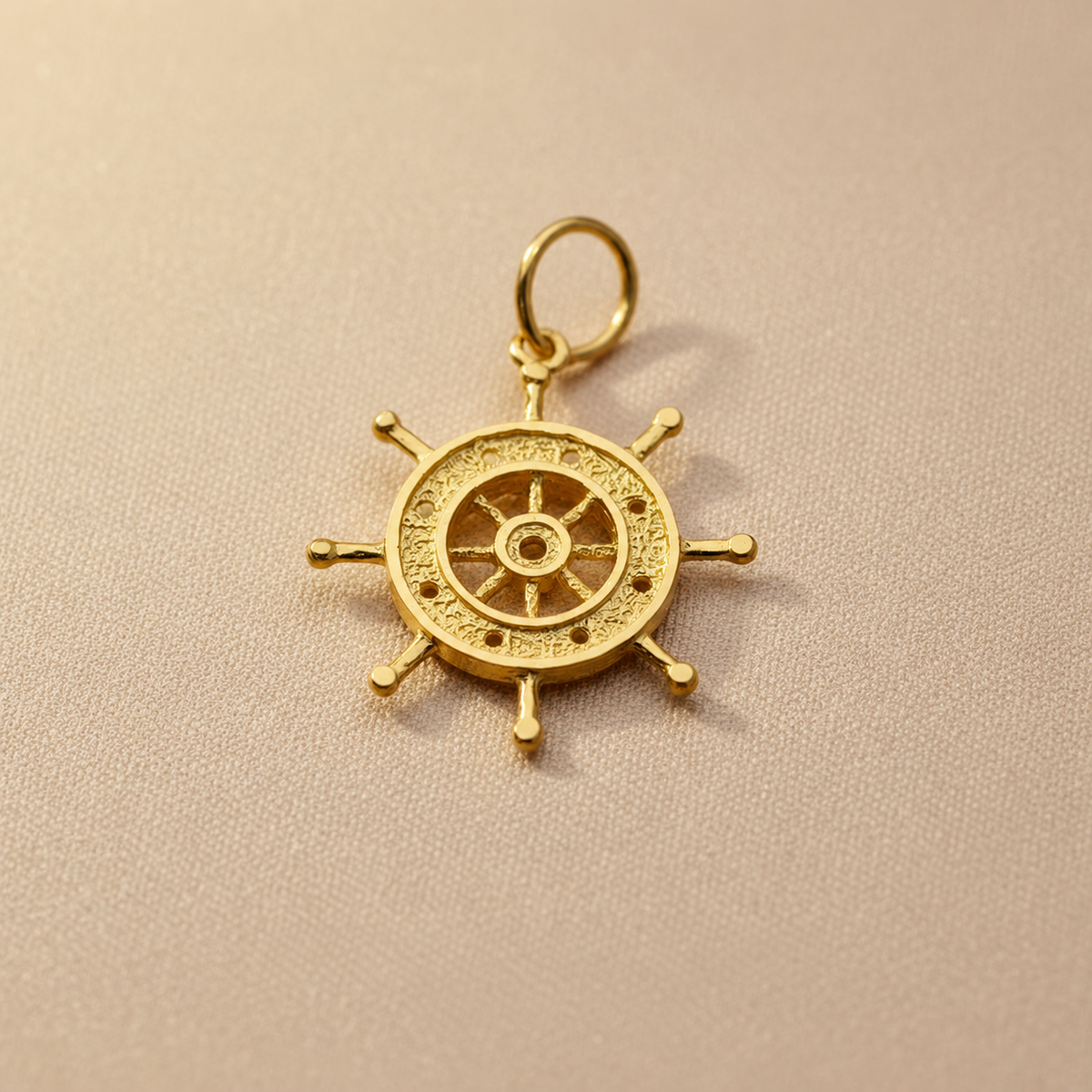 Reverse view of the 916 gold ship’s-wheel pendant with open centre and textured rim