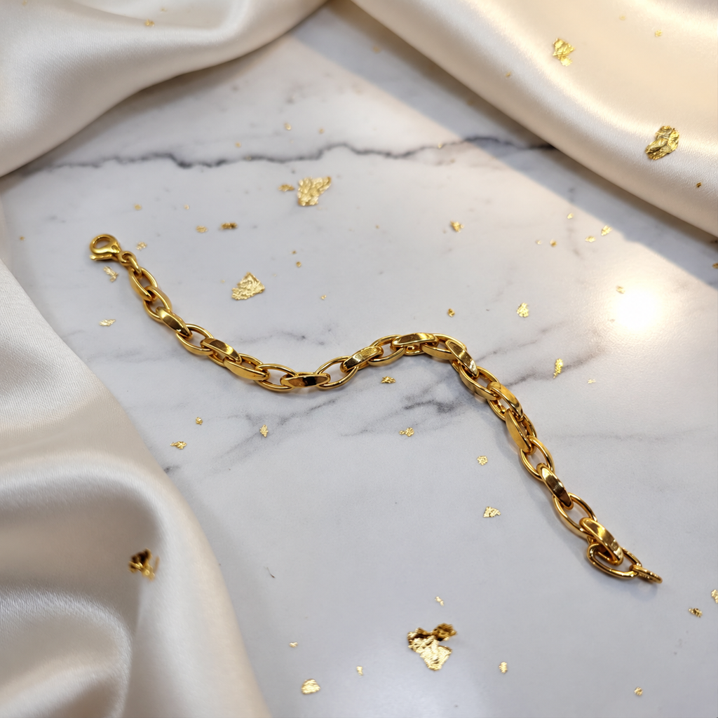 Guild Bullion 22K / 916 gold Oval Anchor Bracelet arranged in a curve on marble with satin, showing lobster clasp and oval links