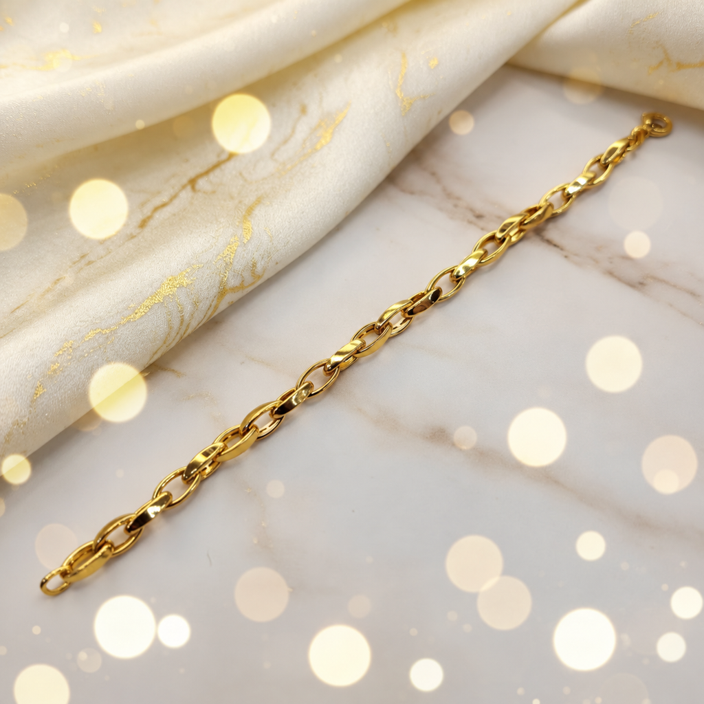 Guild Bullion 22K / 916 gold Oval Anchor Bracelet extended diagonally on marble beside cream satin