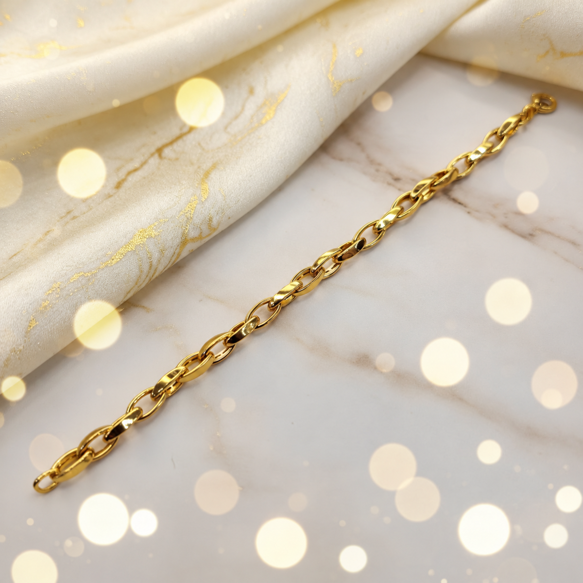 Guild Bullion 22K / 916 gold Oval Anchor Bracelet extended diagonally on marble beside cream satin