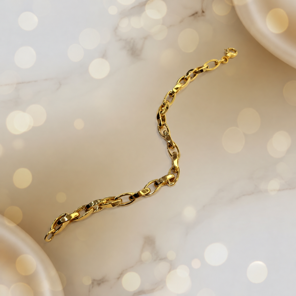 Guild Bullion 22K / 916 gold Oval Anchor Bracelet in a curved arrangement on pale marble with warm bokeh