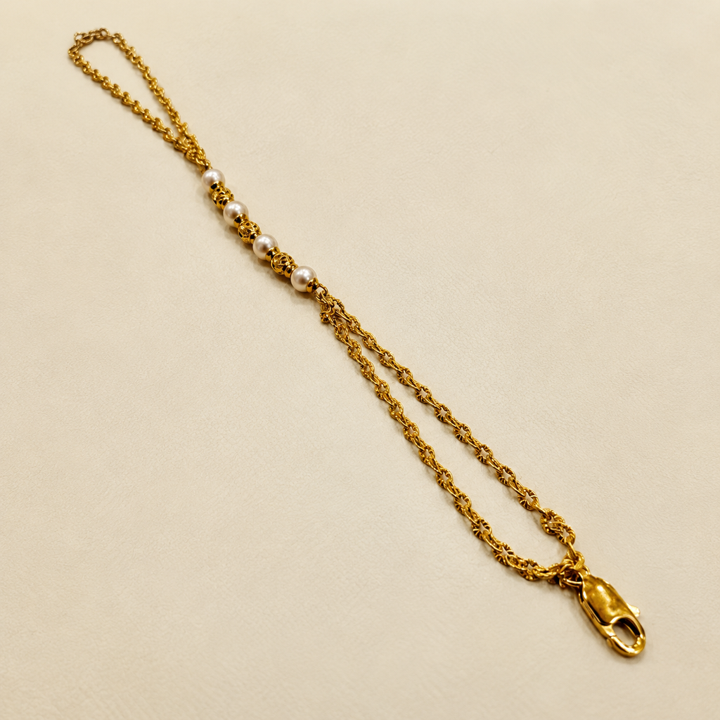 Guild Bullion 916 gold pearl-style bead bracelet with alternating pale and gold openwork beads, double chain and lobster clasp on cream fabric