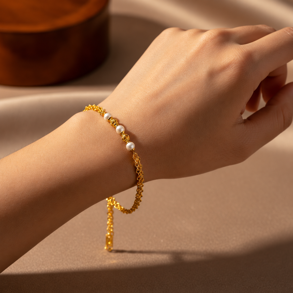 Guild Bullion 916 gold pearl-style bead bracelet worn on a wrist with gold openwork beads and double chain, shown for styling reference