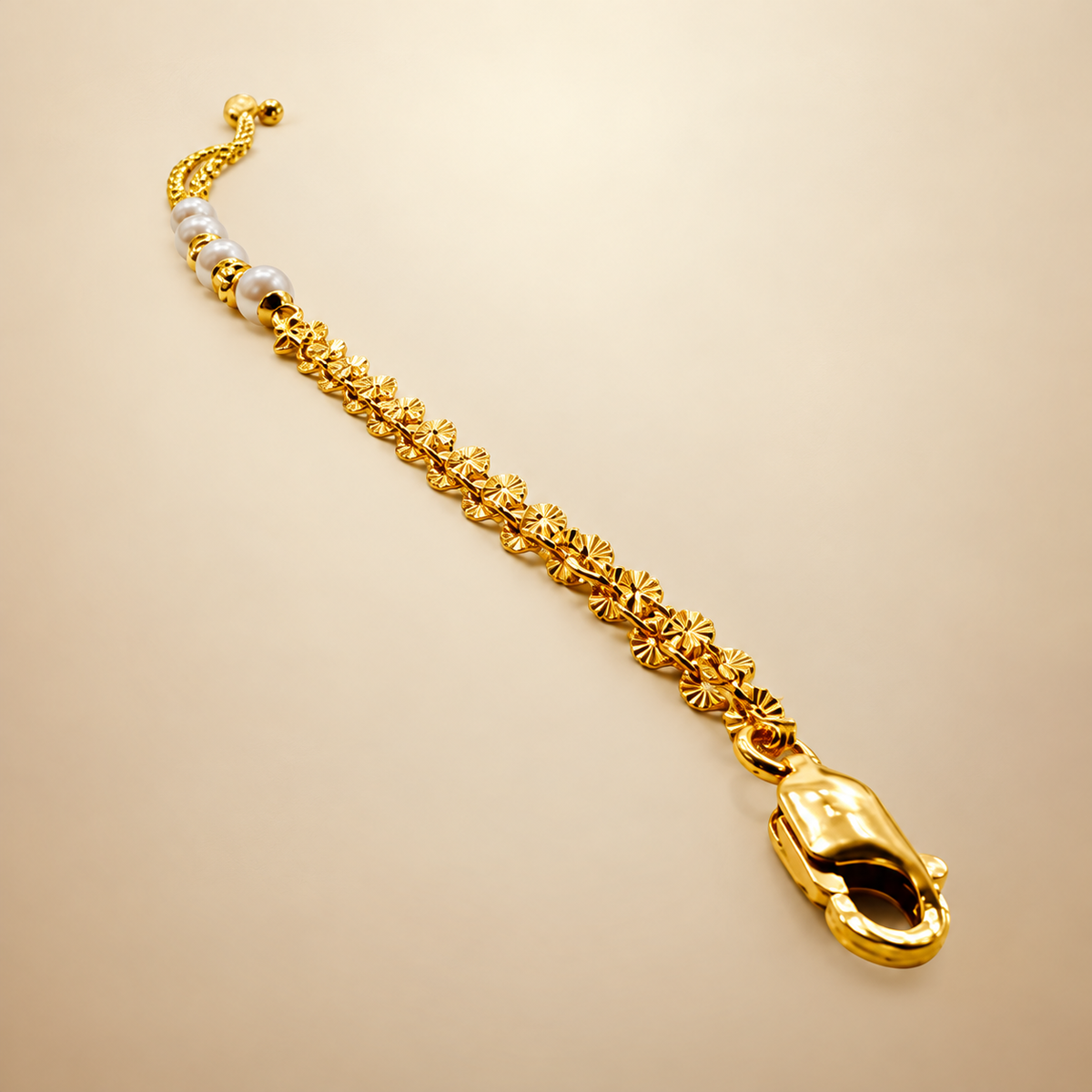 Guild Bullion 916 gold pearl-style bead bracelet chain and lobster clasp close-up on cream fabric