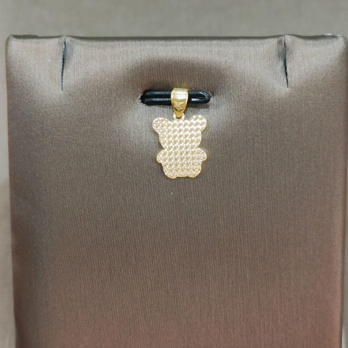 Reverse of the 916 gold bear pendant showing faceted surface texture