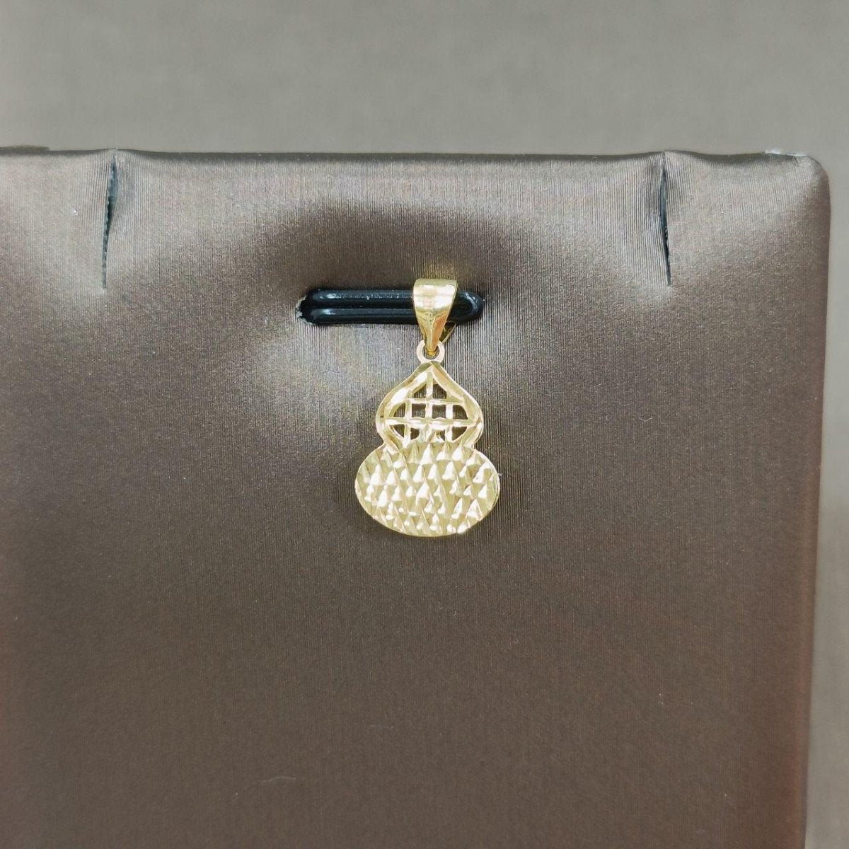 Reverse of the reference gourd-shaped gold pendant showing faceted texture