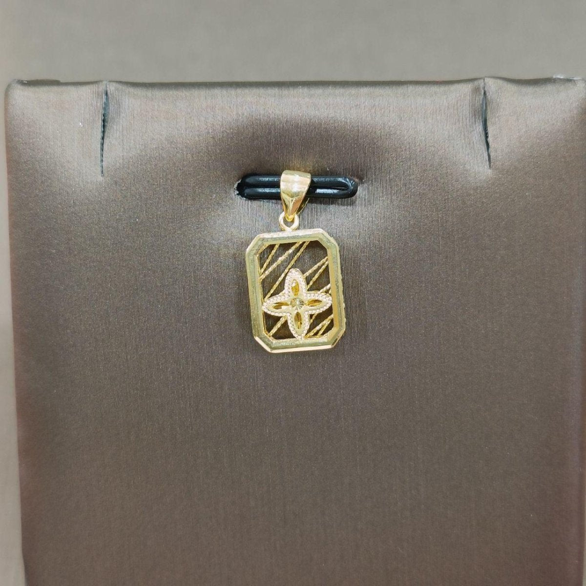 Reference rectangular gold pendant with diagonal lines and a four-petal motif