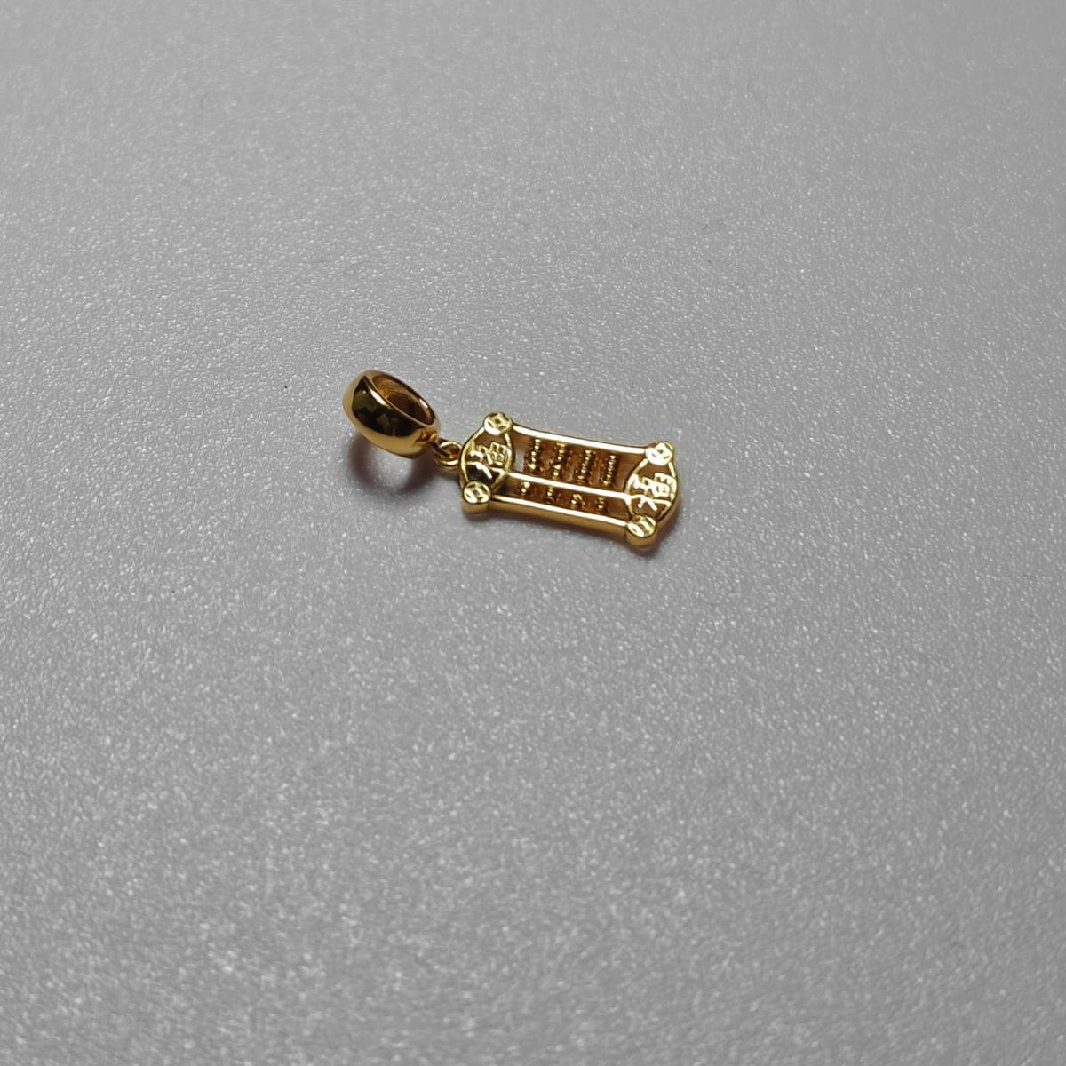 Horizontal view of the 916 gold prosperity abacus pendant showing its elongated frame and decorative ends