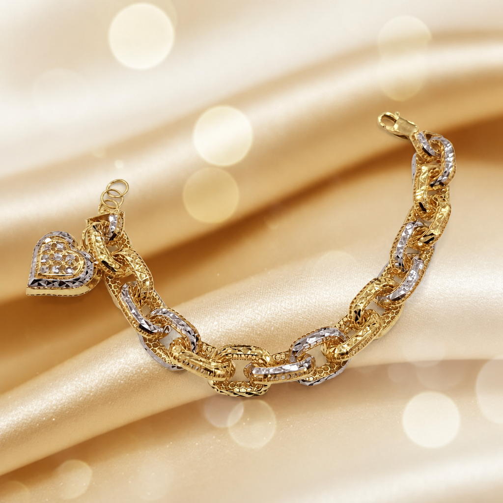 Two-tone 916 gold Regal Link Bracelet with heart charm, textured links, lobster clasp and extension rings on gold satin