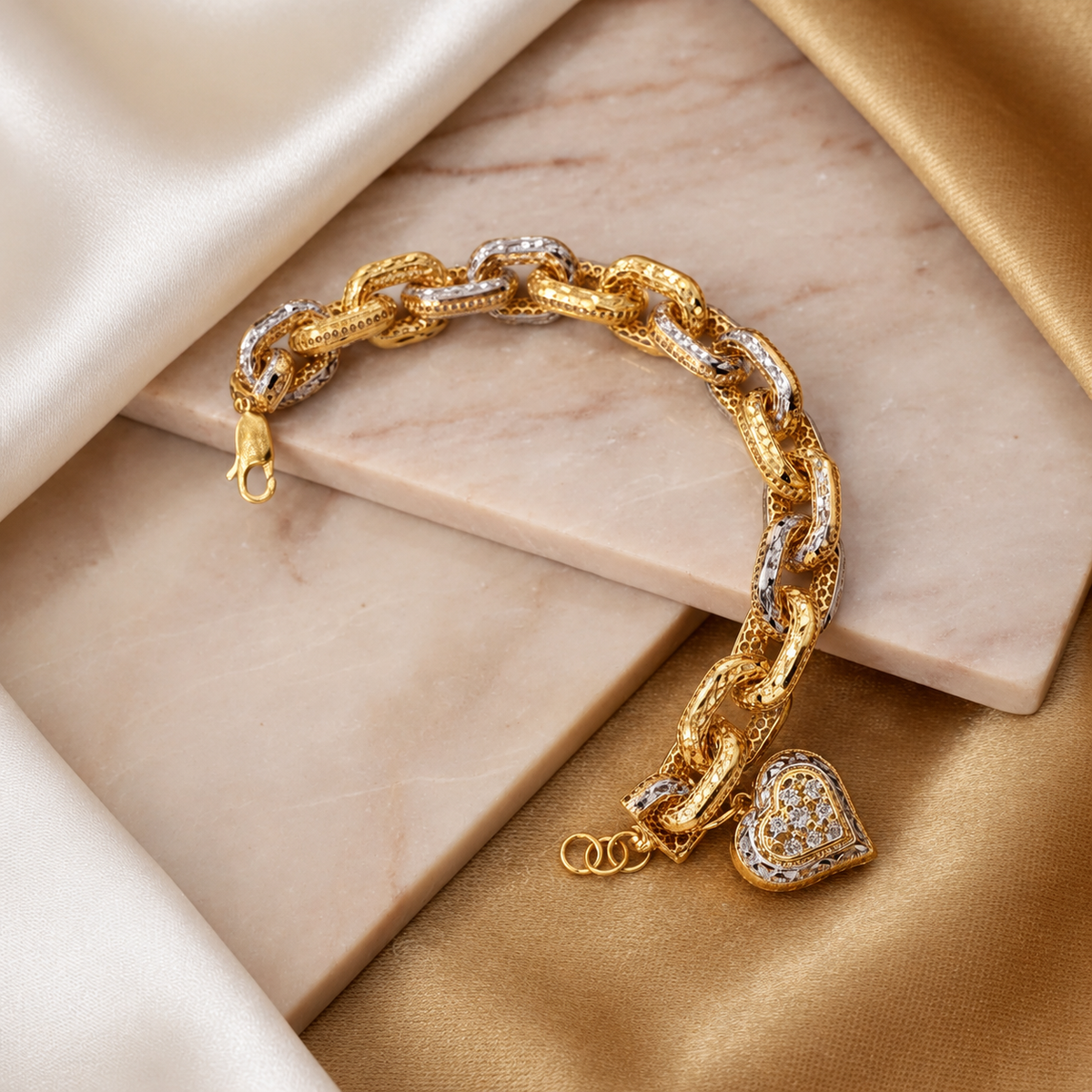 916 gold Regal Link Heart Charm Bracelet arranged across pale marble, showing two-tone textured links and extension rings