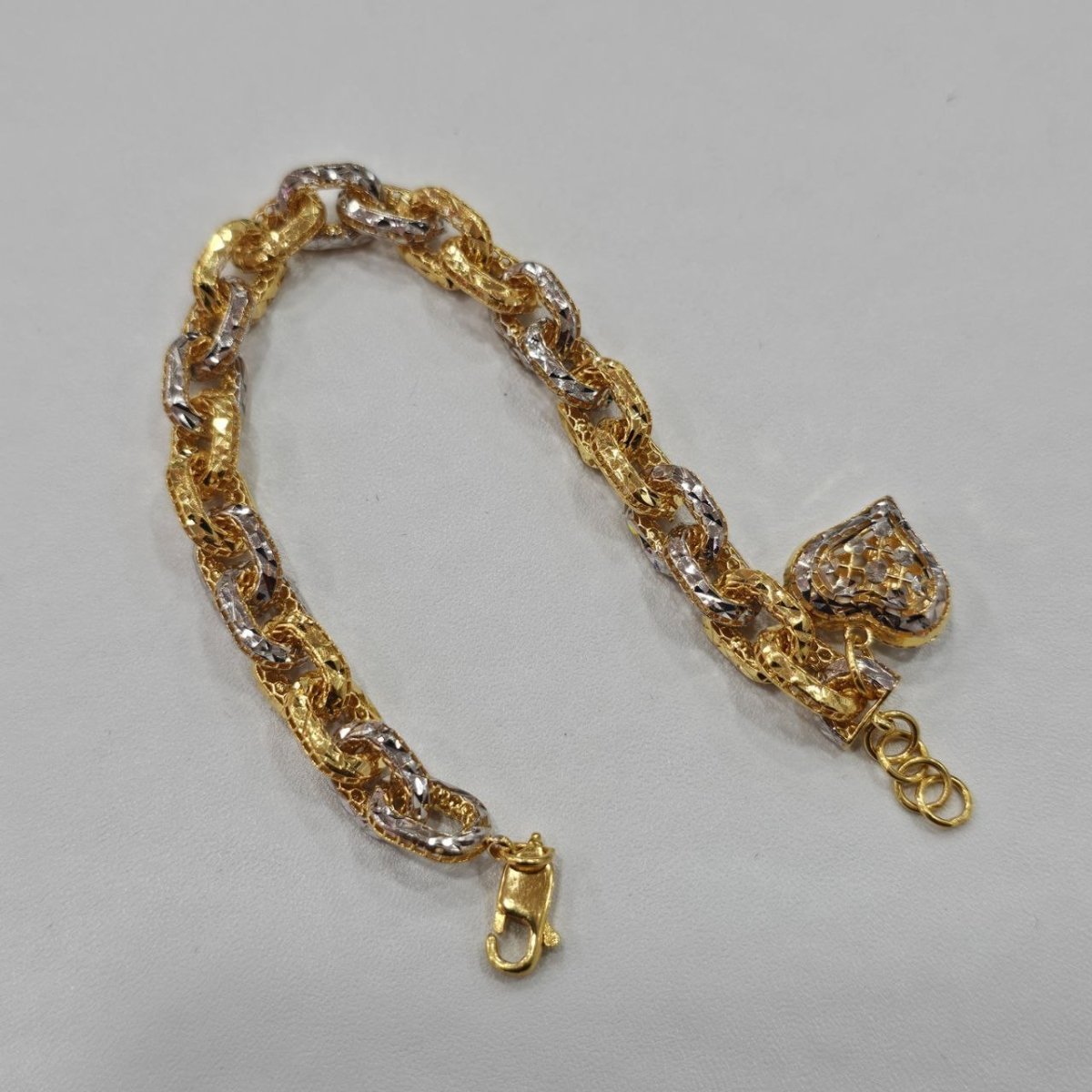 Original front view of the 916 gold Regal Link Bracelet showing the two-tone heart charm and textured links