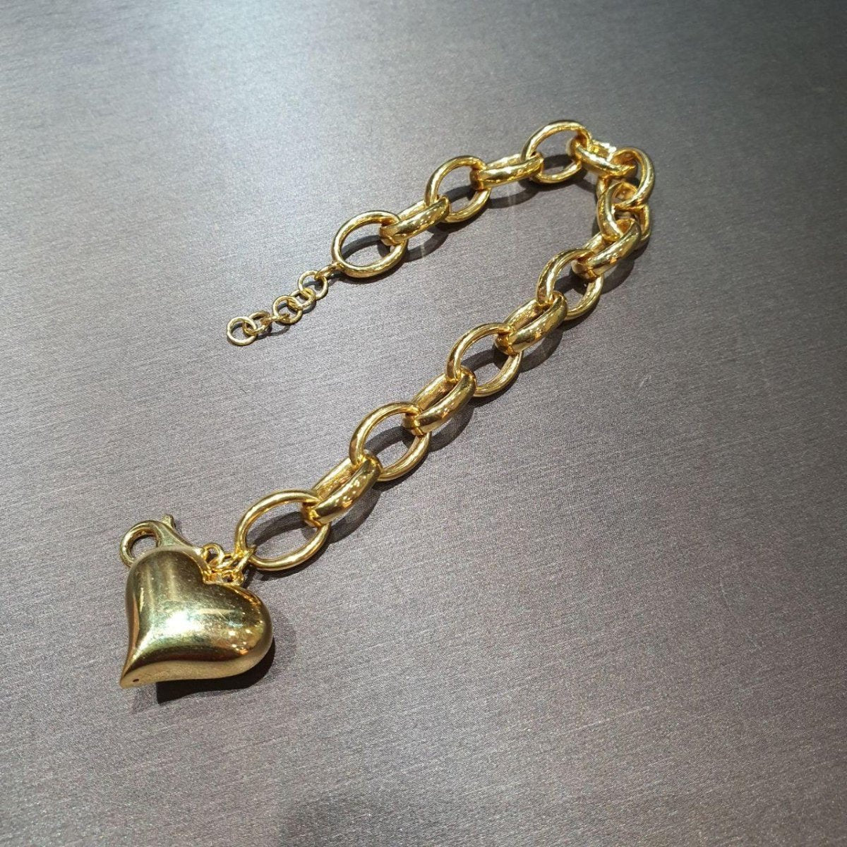 Close view of the 22K gold ring-link bracelet with polished heart pendant, round links and extension rings