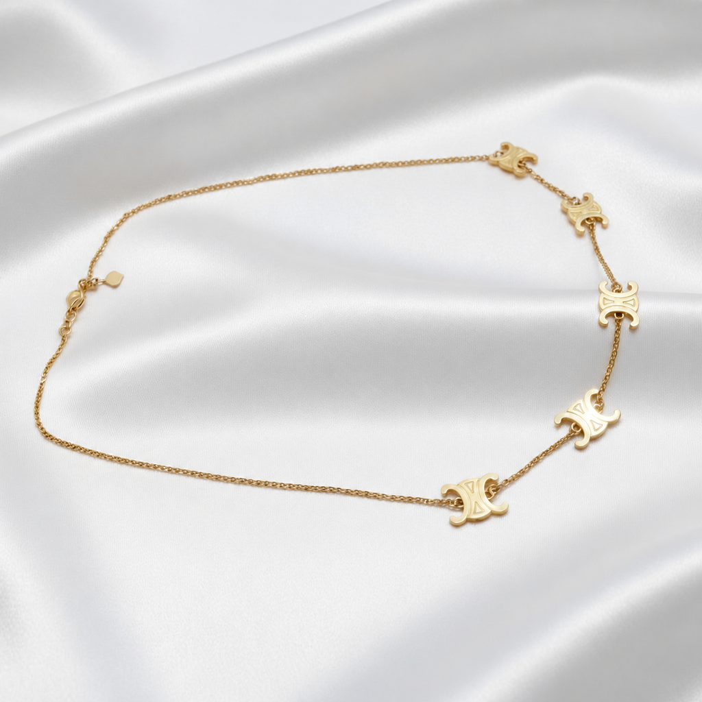Angled view of the 22K gold Scroll Link Chain showing five polished scroll motifs and adjustable clasp