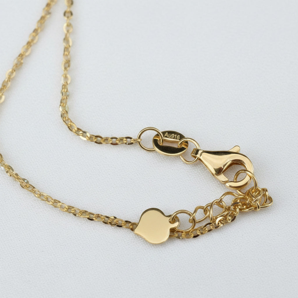 Close-up of the 916 gold Scroll Link Chain lobster clasp, extension chain, end tag and Au916 marking