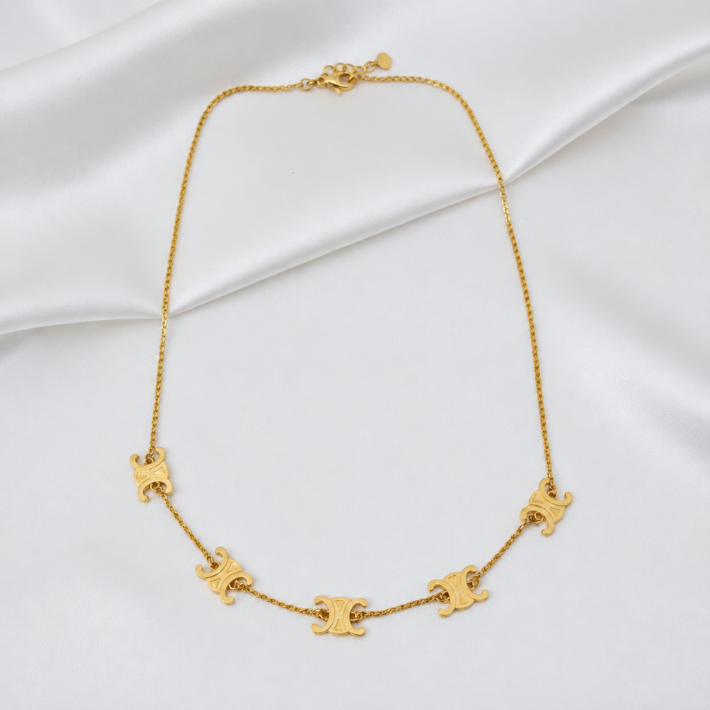 Front view of the 916 gold Adjustable Scroll Link Chain with five engraved motifs on white satin