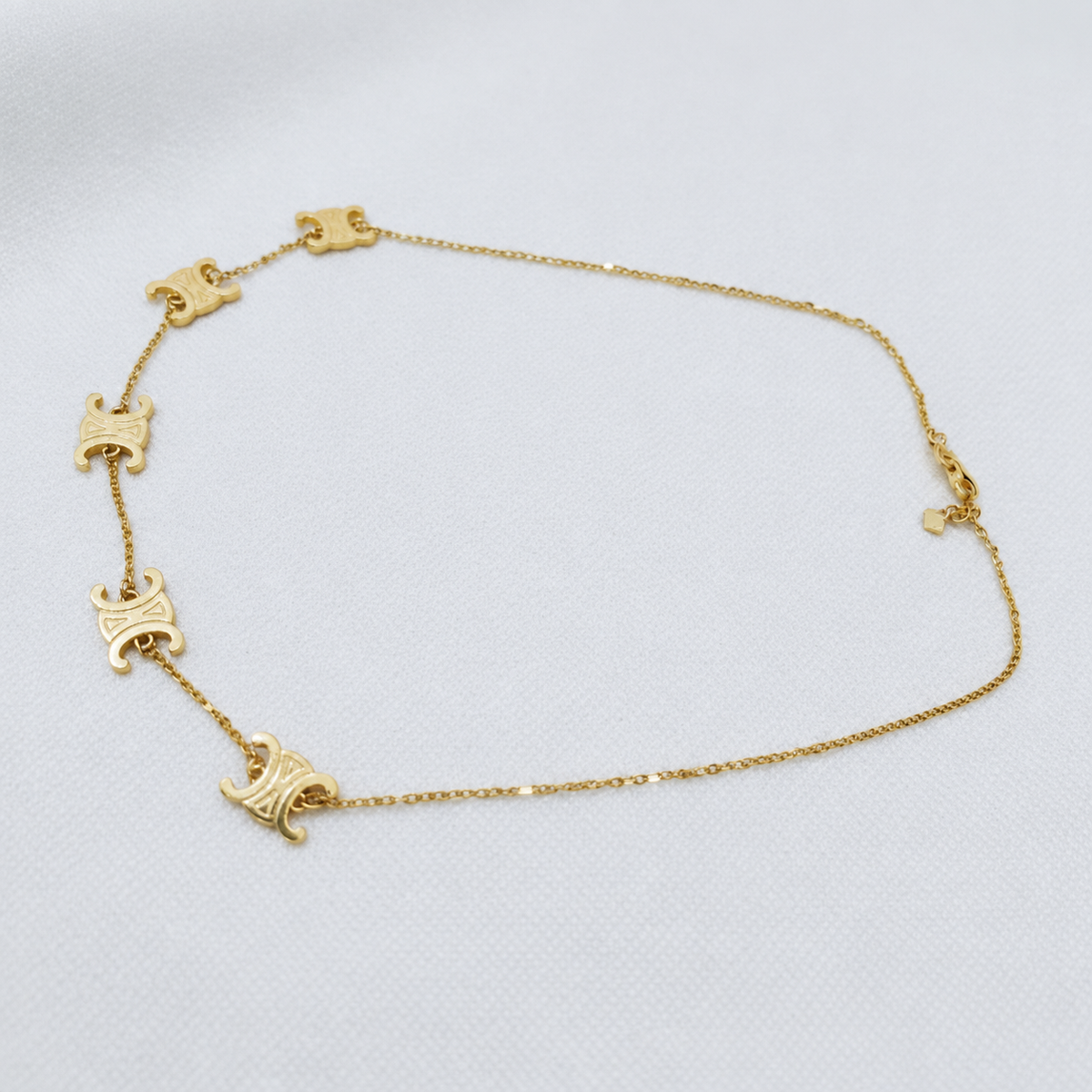 Full necklace view of the 22K gold Adjustable Scroll Link Chain with five decorative motifs and extension chain