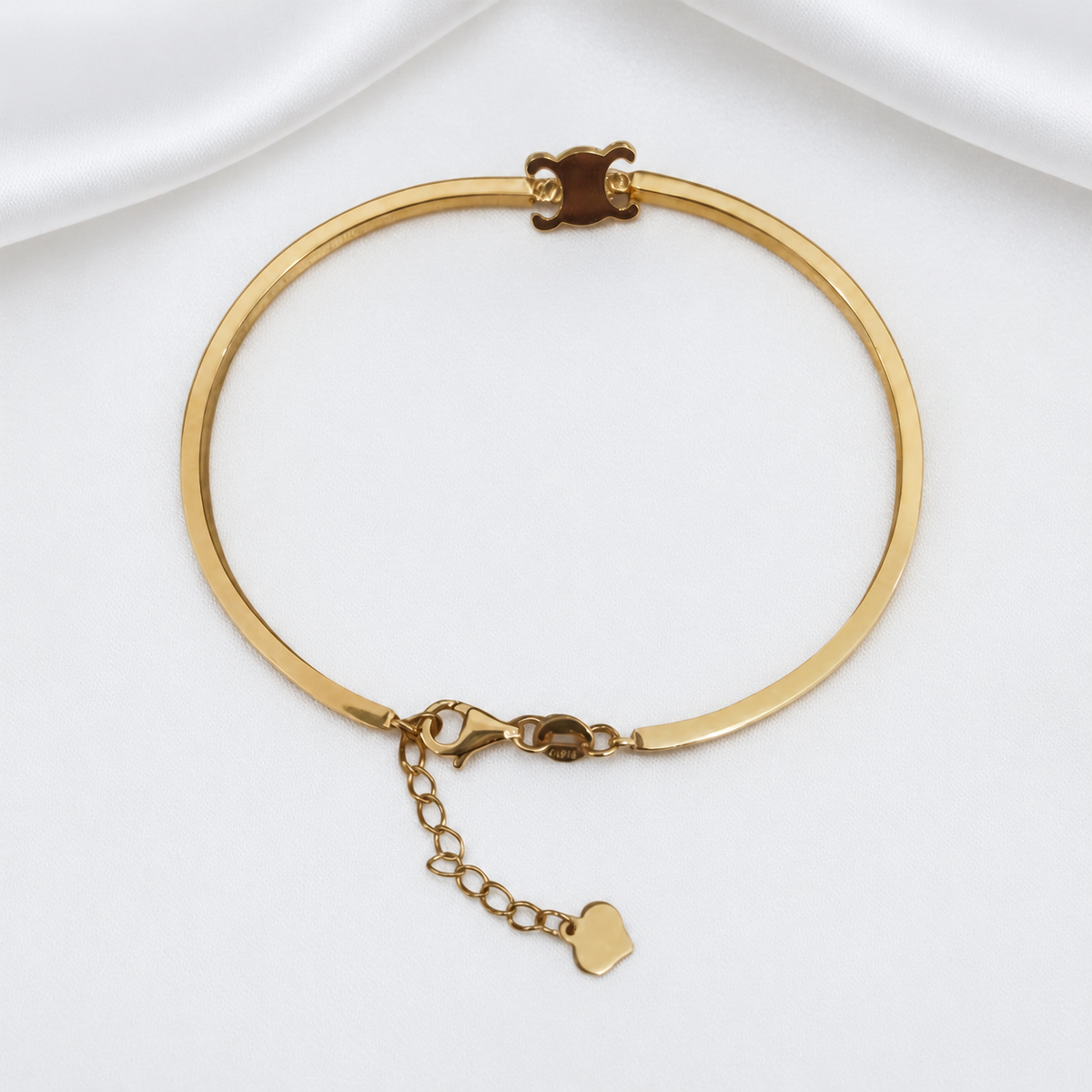 Front view of the 916 gold adjustable Scroll Motif Bangle with a polished band, clasp and extension chain
