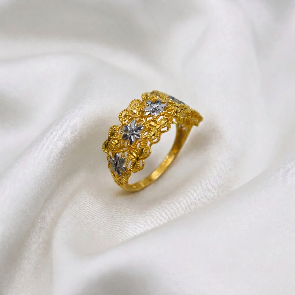 Angled view of the 916 gold Serenity Petal two-tone ring with silvery-coloured flowers and yellow-gold openwork on white fabric