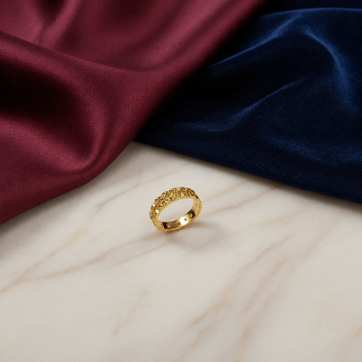 916 gold Slim Keeper lightweight ring with geometric openwork on marble beside burgundy and navy fabric