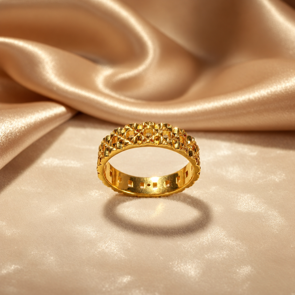 Front view of the 916 gold Slim Keeper ring on gold satin showing geometric facets and openwork