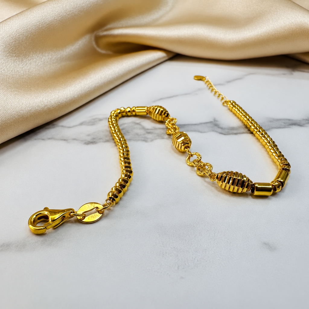 Guild Bullion 22K / 916 gold triple oval bracelet angled on marble with lobster clasp and extension chain visible