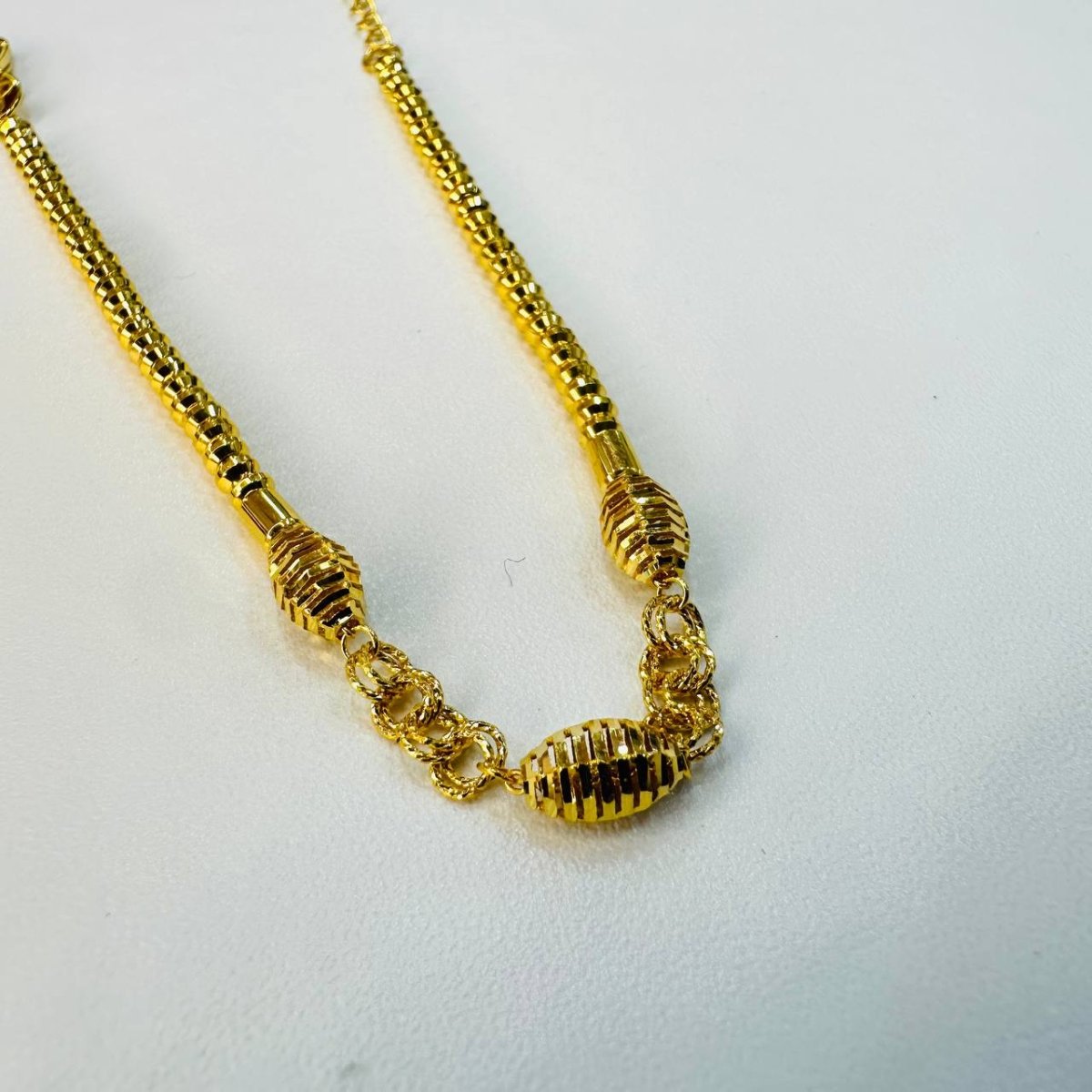Guild Bullion 22K / 916 gold triple oval bracelet close-up of three ribbed oval beads and textured connecting links