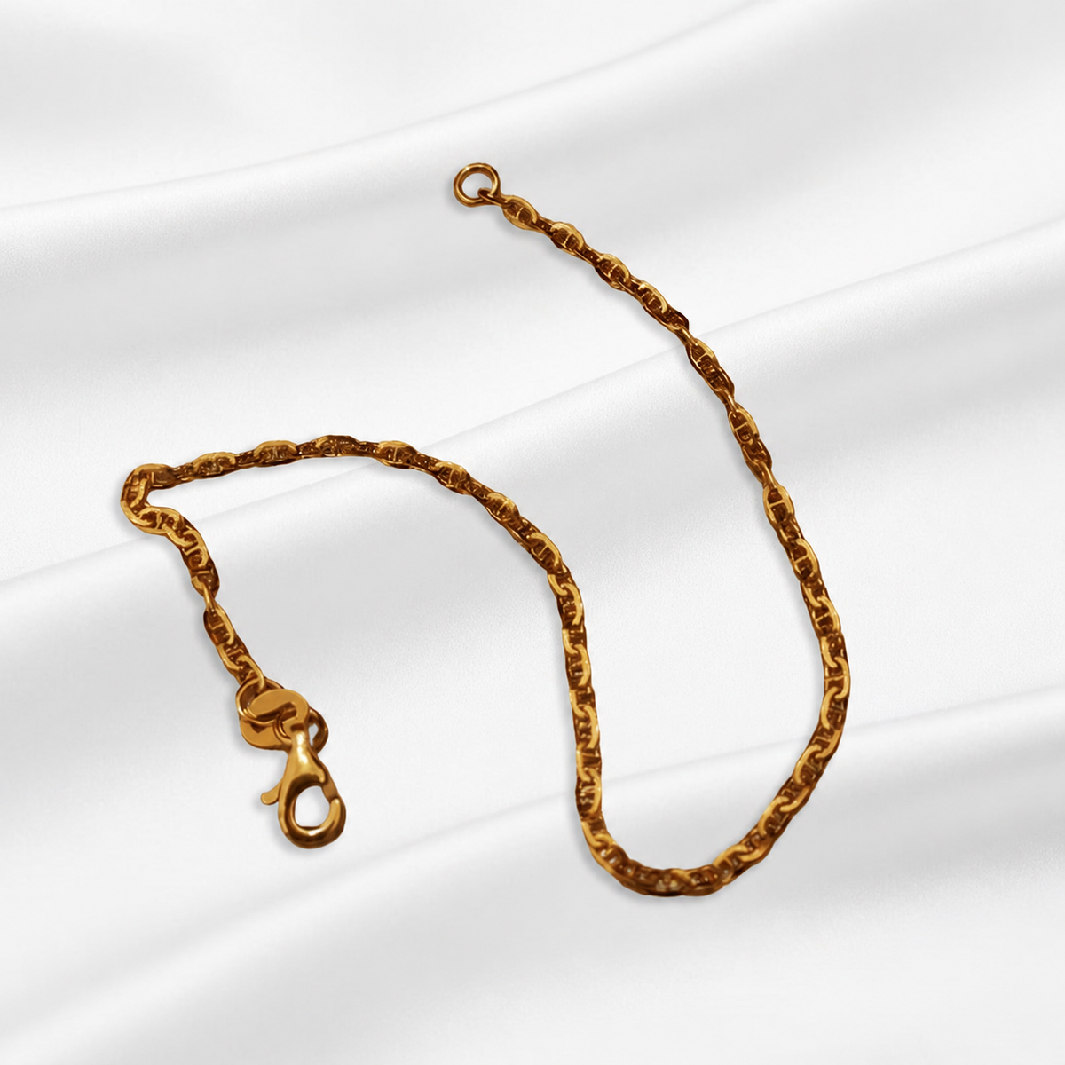 Full view of the Guild Bullion 916 gold Twisted Link Bracelet with lobster clasp and end ring on white satin