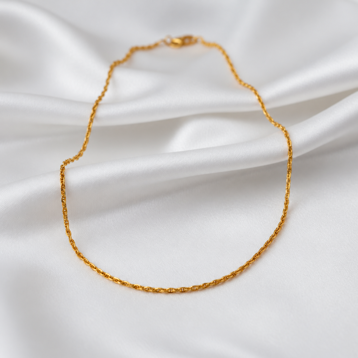 Guild Bullion 22K gold twisted link necklace in a full oval arrangement on white satin