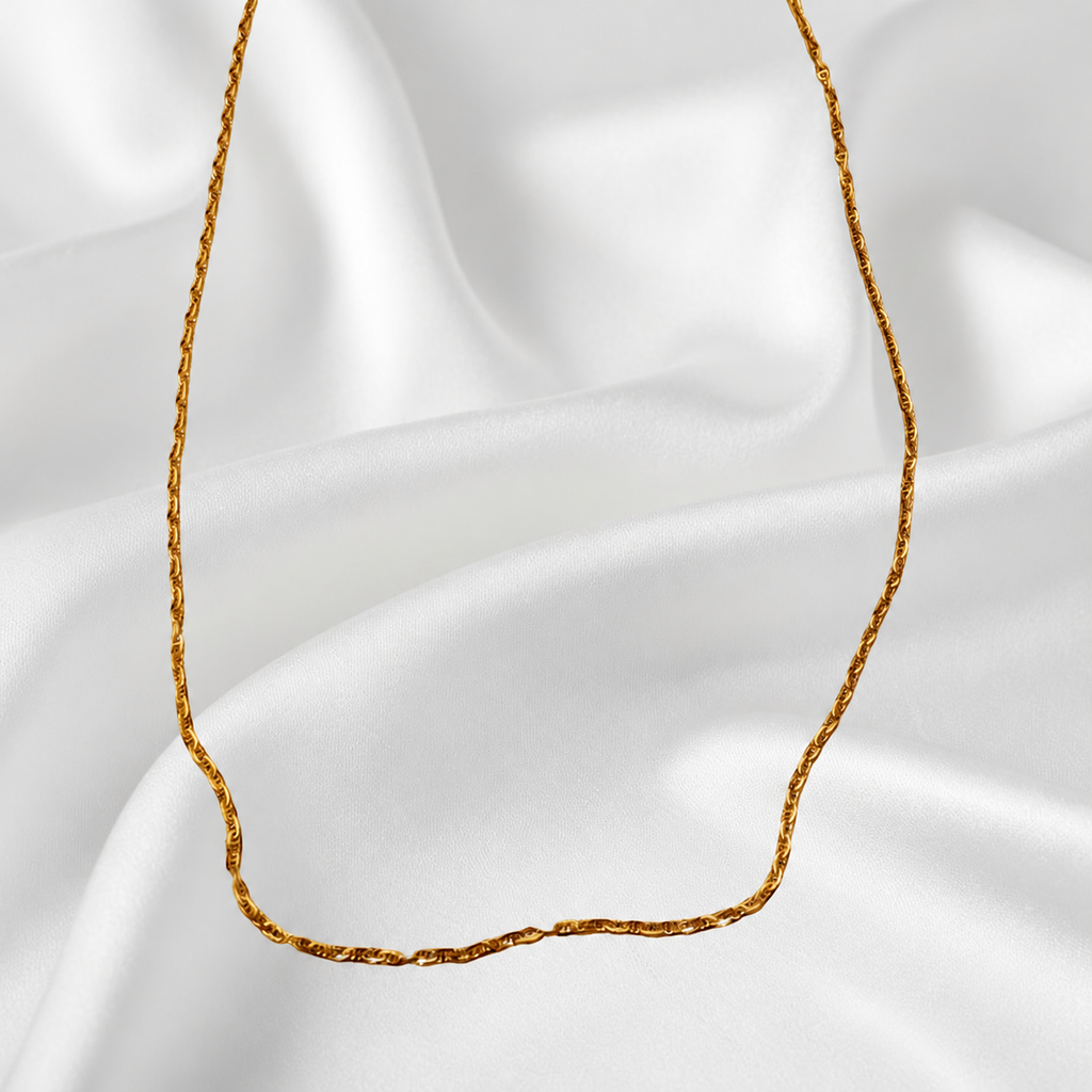 Guild Bullion 916 gold necklace detail showing the slim twisted link chain against white satin