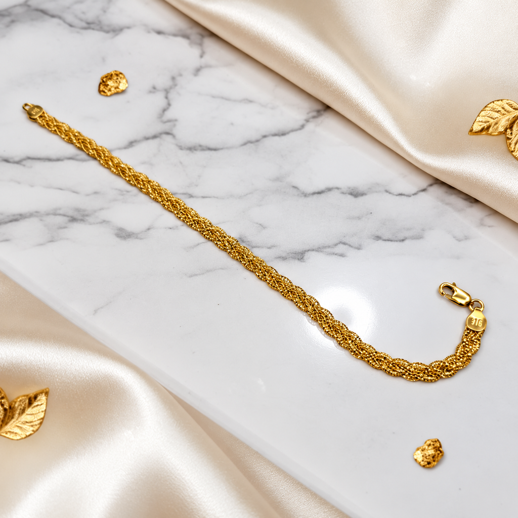 916 gold Wave Braided Bracelet extended on white marble beside cream satin with lobster clasp and 916 end cap