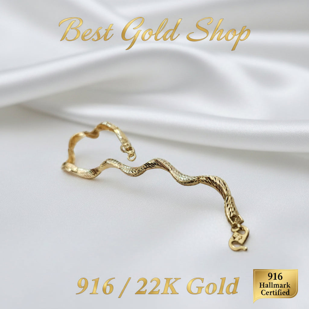 Side angle of a 916 gold cut-finish Wavy Bracelet on satin with clasp in the foreground